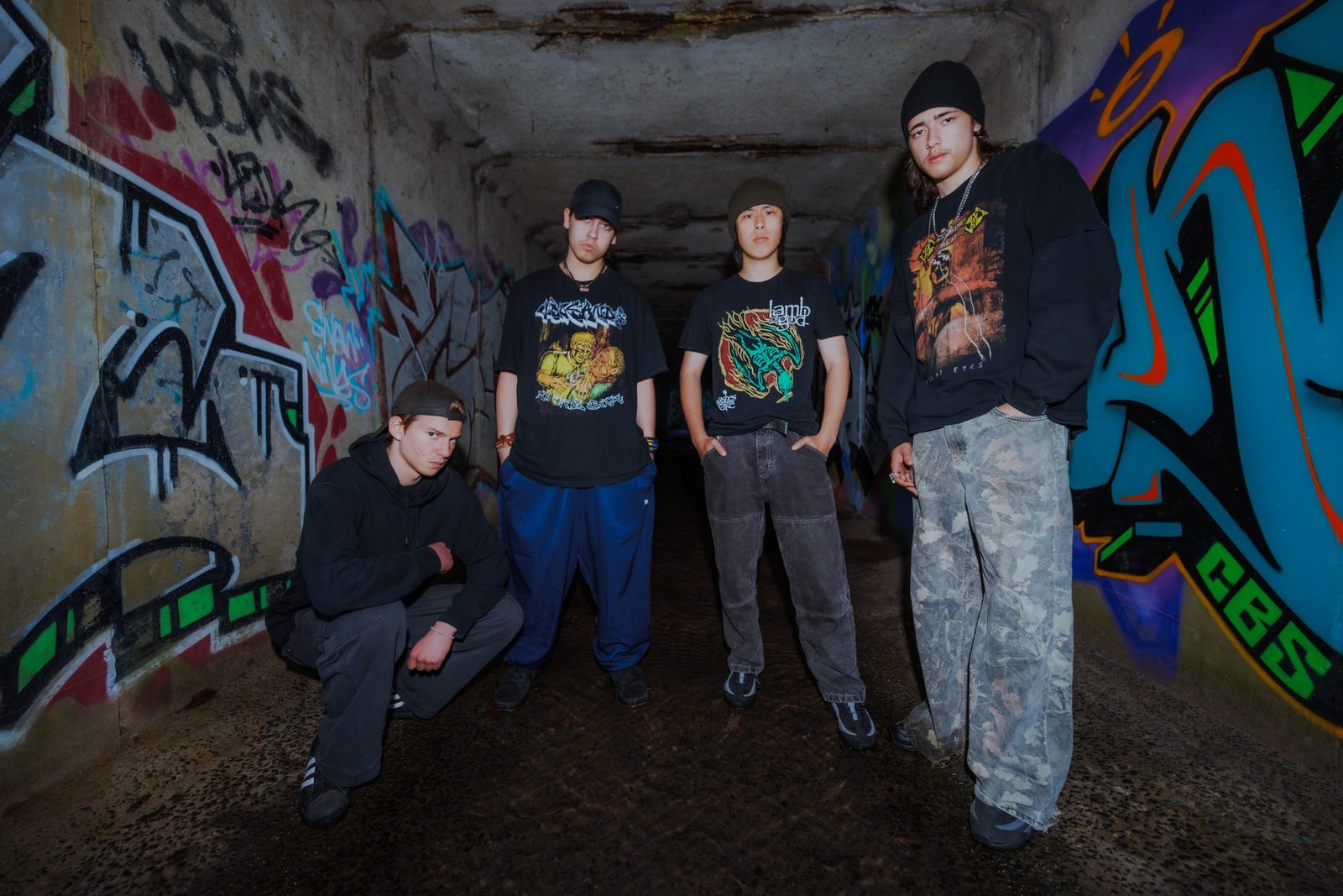 KNEED photographed together in a graffiti-covered tunnel