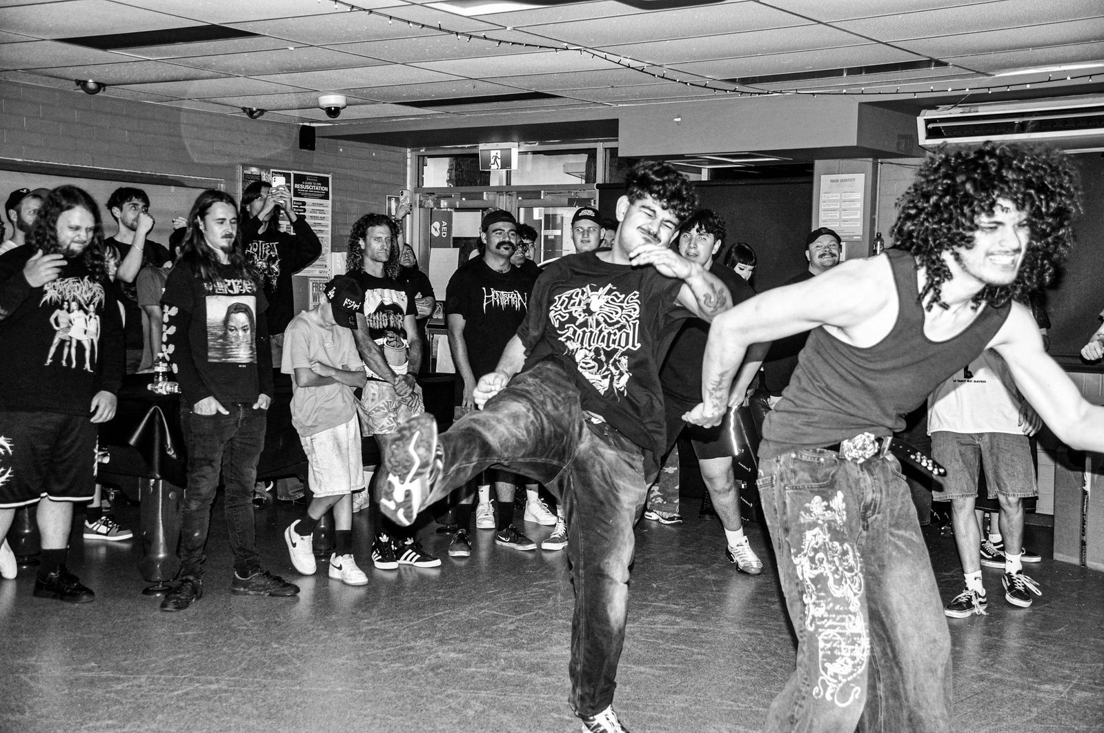 A mosher mid-kick in the pit during a KNEED set
